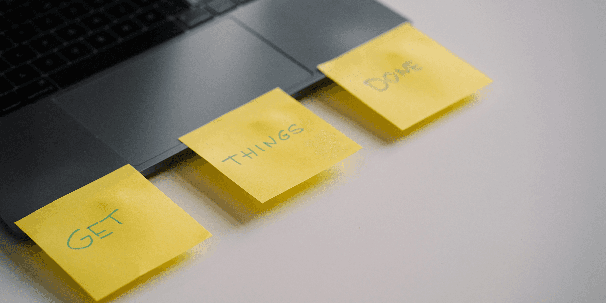 picture of a laptop with three post-it notes attached to it with the text "get", "things", "done" on them