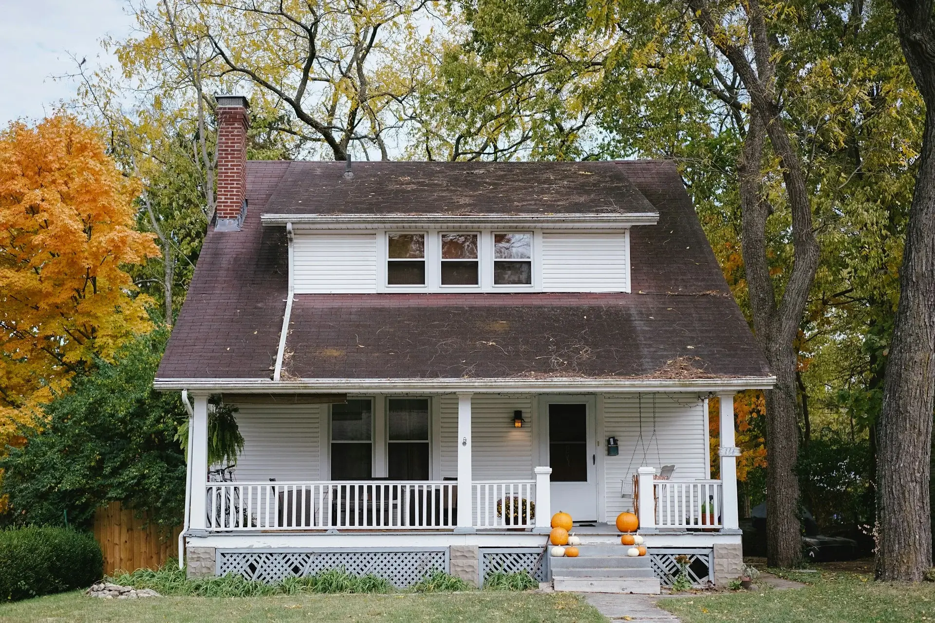 White cottage with front porch.