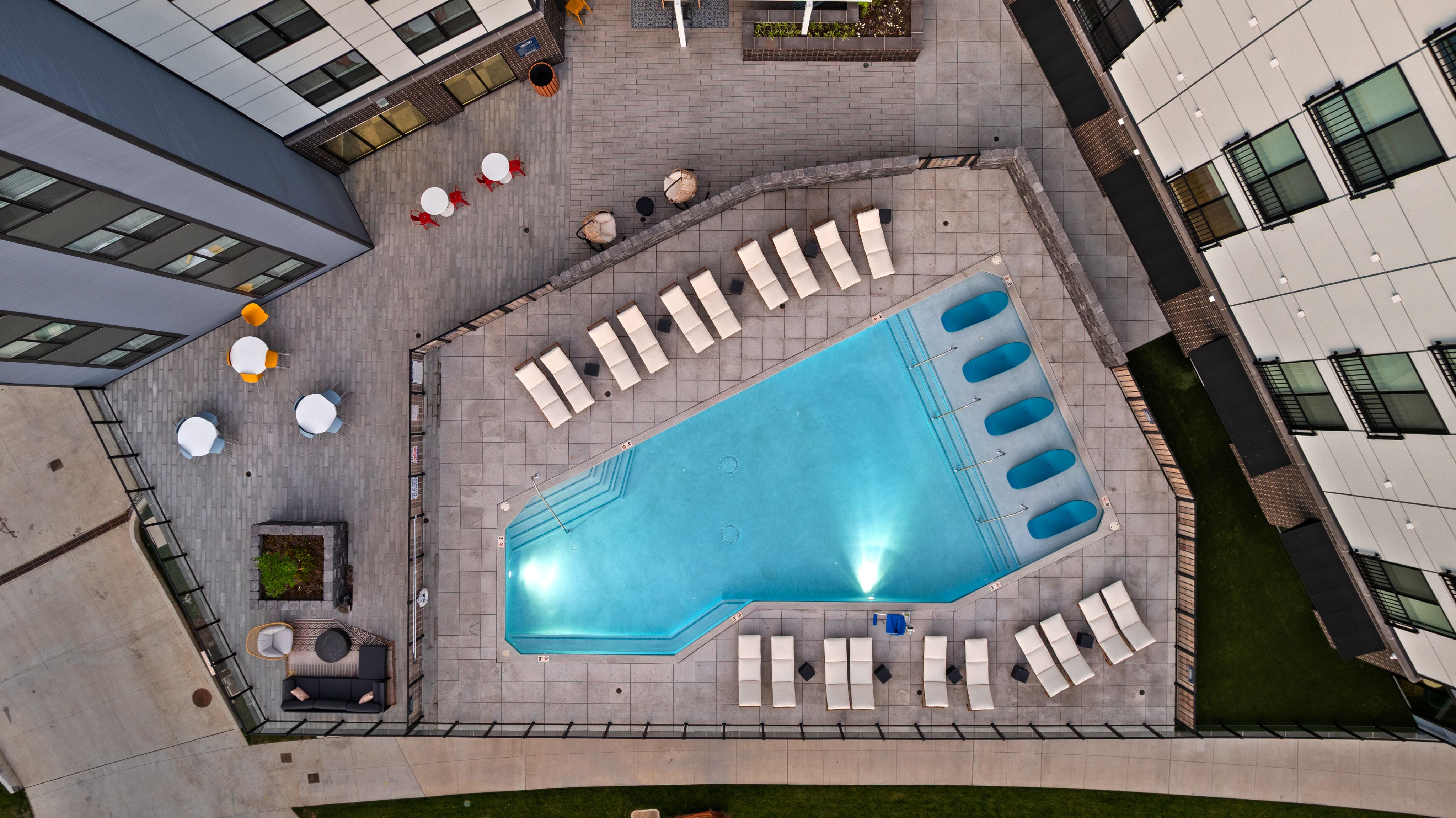 Aerial view of a swimming pool surrounded by lounge chairs, showcasing a relaxing outdoor space.