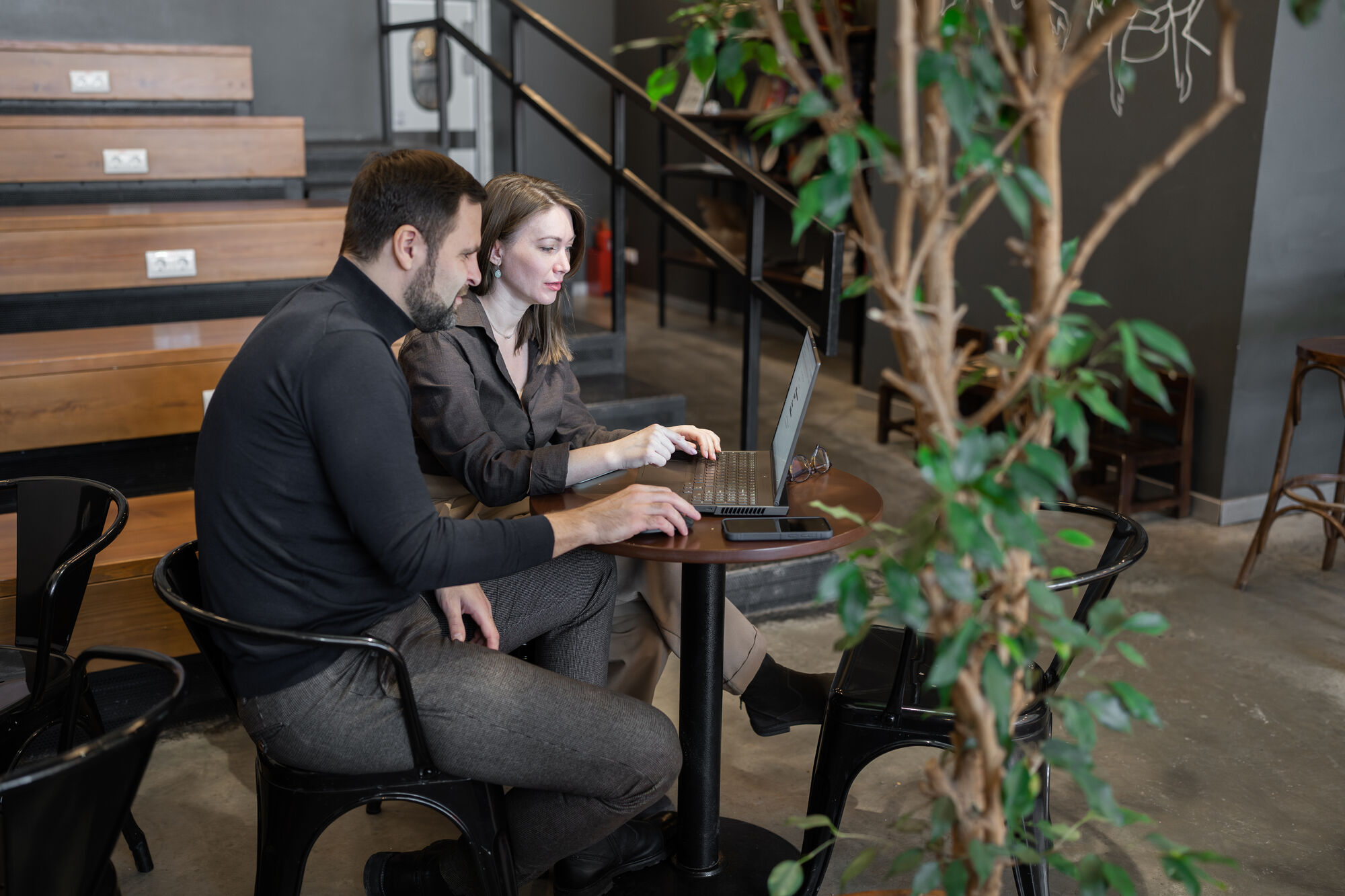 A man in a white lab coat working at a computer, viewing a 3D model on the screen in a laboratory or office setting.