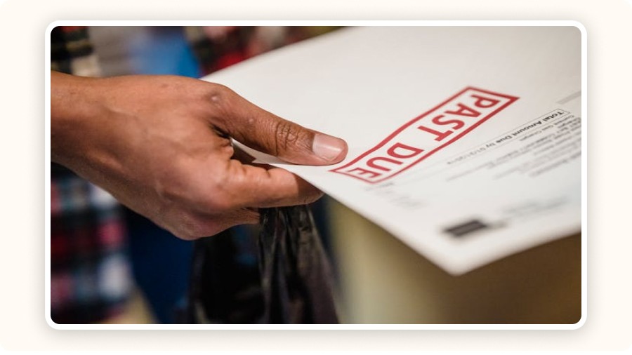 Hand holding a “Past Due” invoice