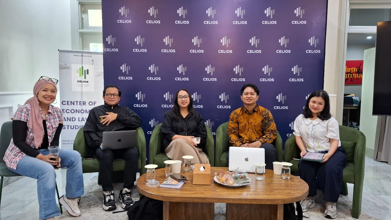 Close-up of lush, dark green leaves, some glossy and wet, against a muted background.