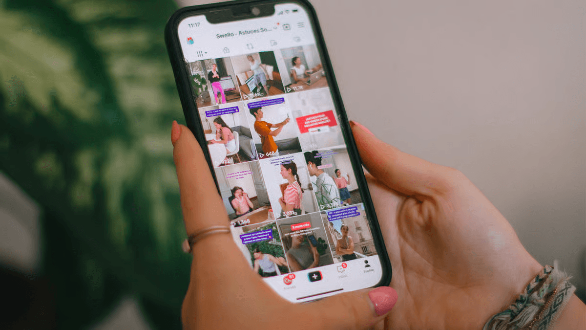 Person using phone displaying video grid -  How to Make Brainrot Videos