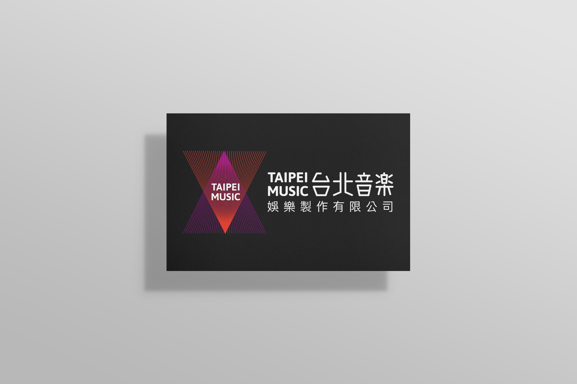 這張圖像展示了台北音樂的名片設計。黑色名片上有紫紅色漸層的三角形線條的品牌識別，白色字體展示 "TAIPEI MUSIC 台北音樂 娛樂製作有限公司"。
