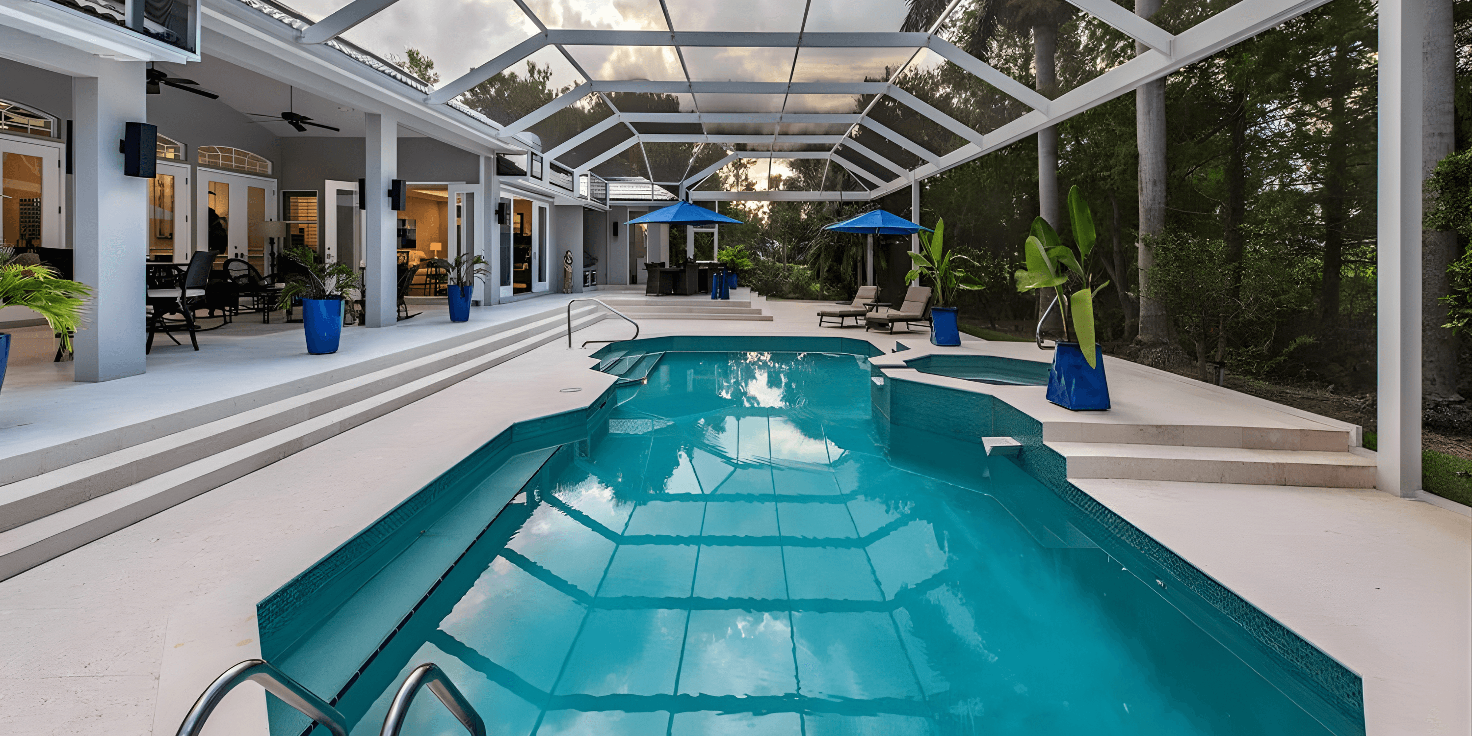 a resort styled pool inside of a cage outside the back of a home with blue umbrellas
