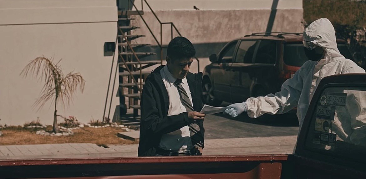 View of the French countryside through a stone villa’s open living room, with sofas and trees framing the scene