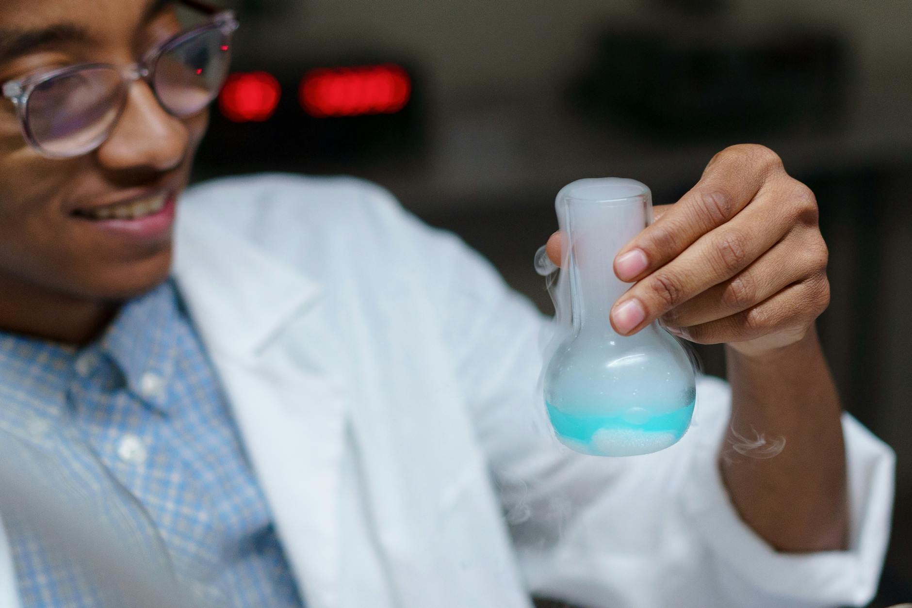Two middle school students in a science lab collaborating on a chemistry experiment at a wooden desk.