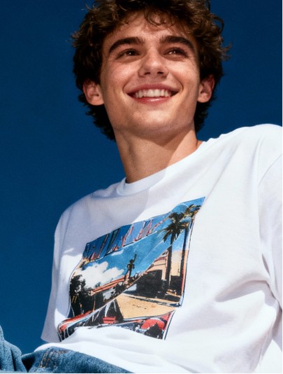 A university student looking up out in the distance, smiling.