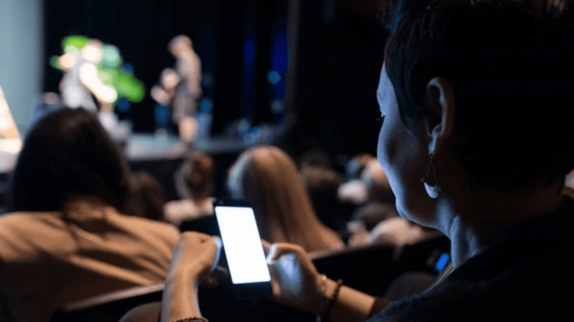 A winding road cuts through rocky terrain, surrounded by patches of green grass and illuminated by sunlight.