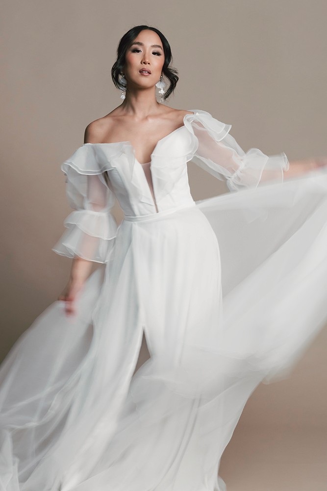 Bride mid-turn with a flowing tulle skirt in motion, soft studio light, fine art bridal editorial by Eva Sitko