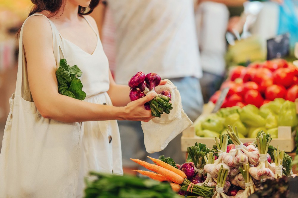 image of grocery shopper using a reusable tote bag made from recycled material 