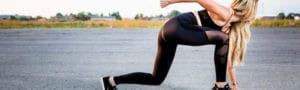 woman wearing black leggings, black crop top, and black Nike running shoes