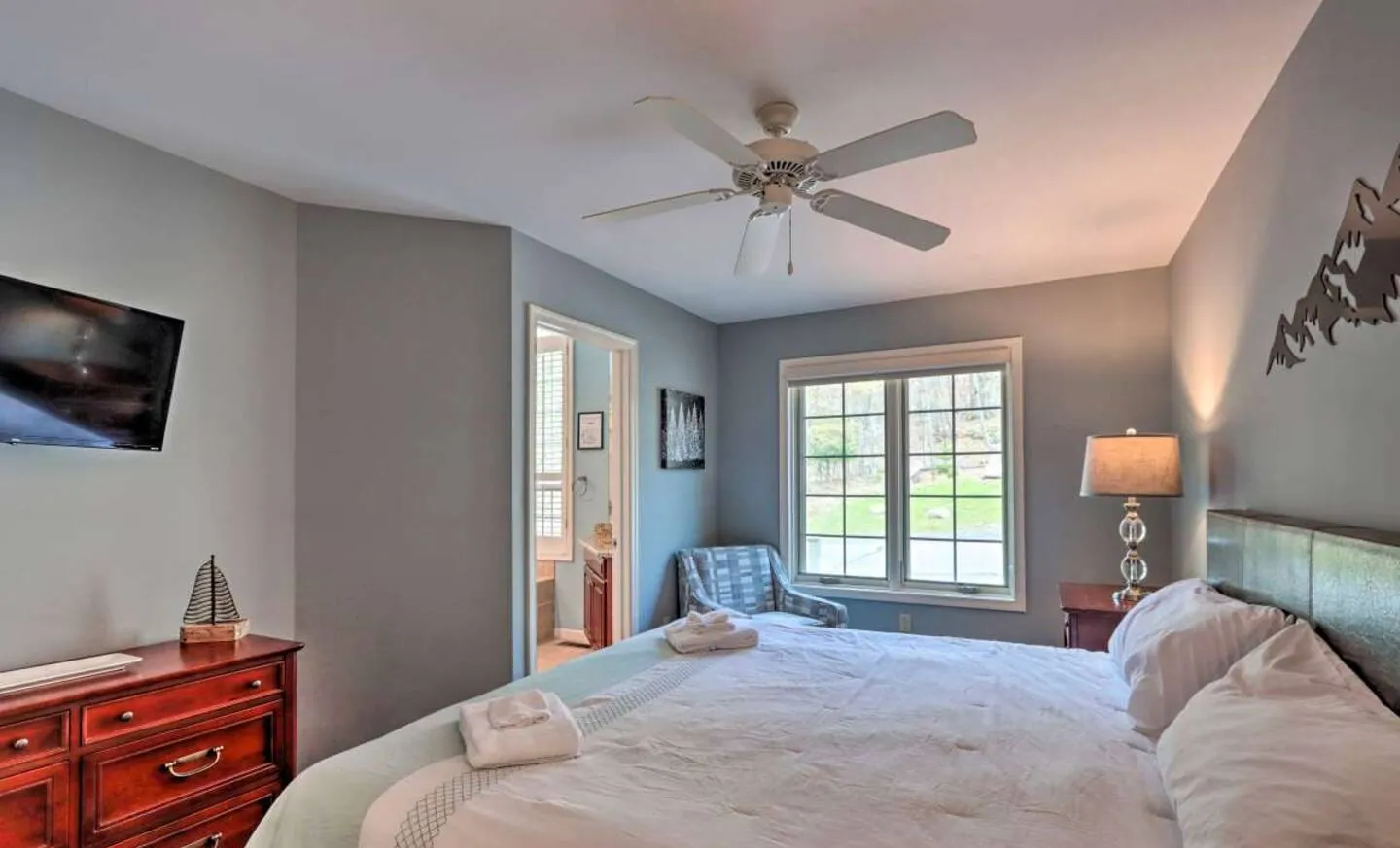 First floor primary bedroom with king bed, ceiling fan and cherry dresser at SummitWind