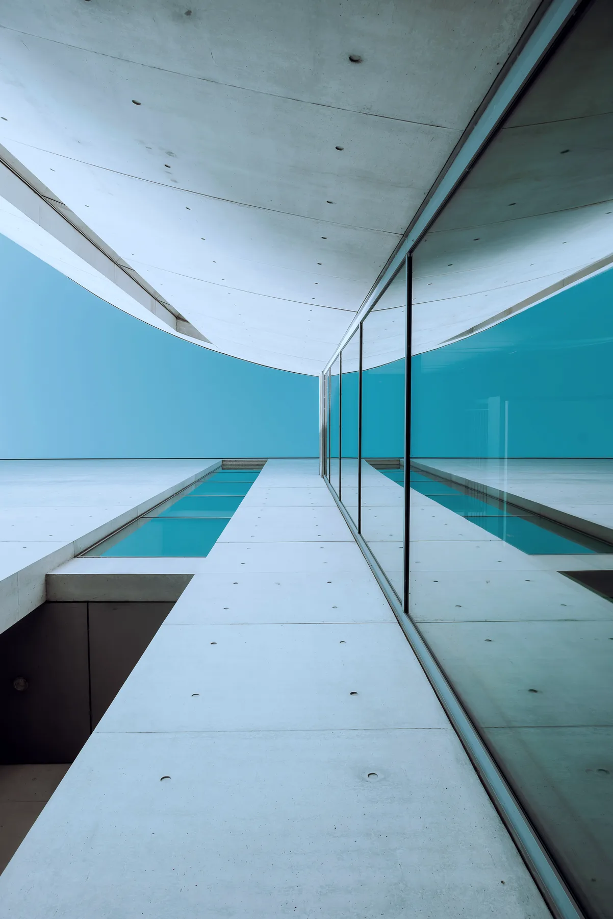 Concrete corridor beside blue water