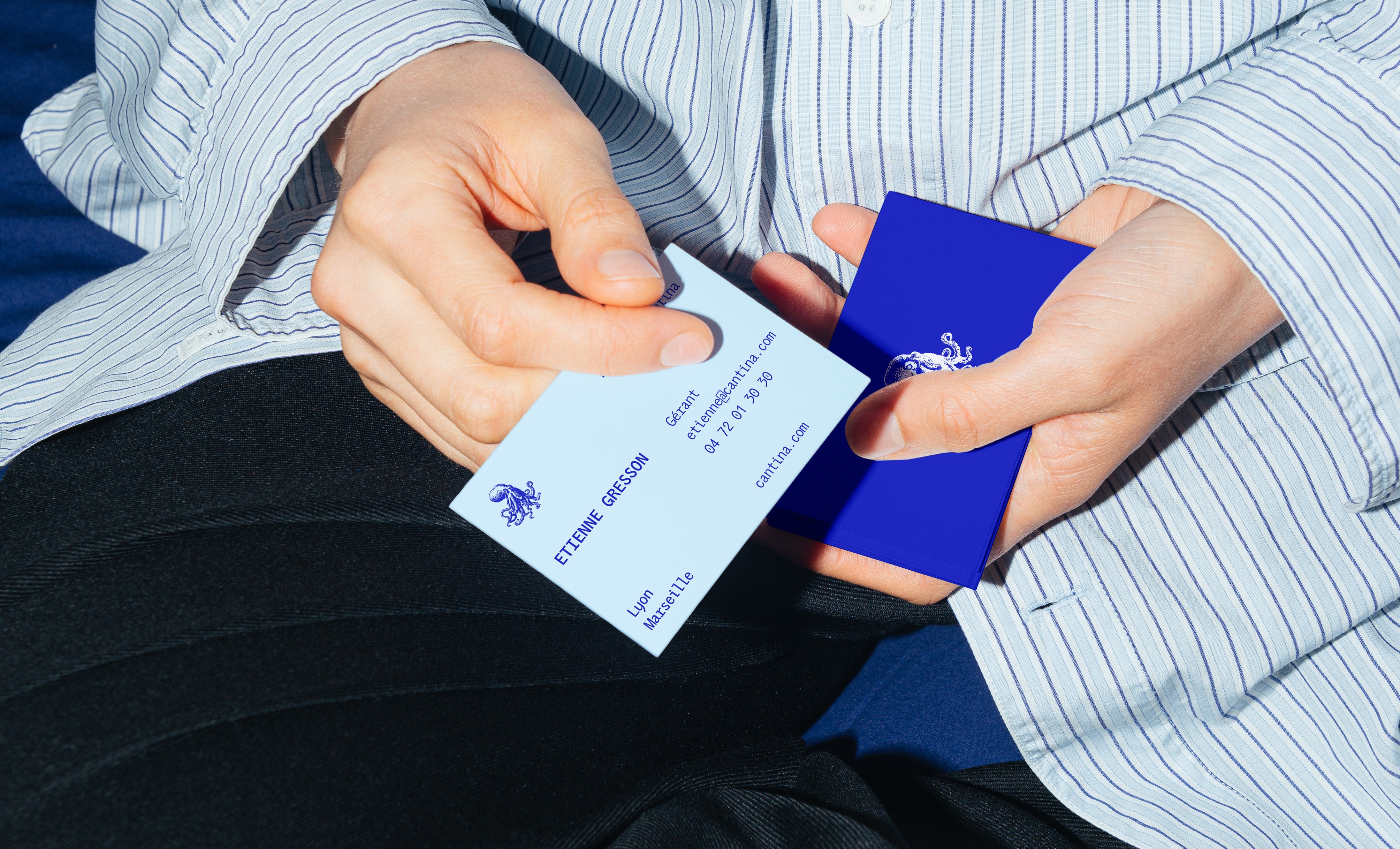 A close-up of a pink cocktail in a martini glass, set against a nighttime background with soft, blurred colors.