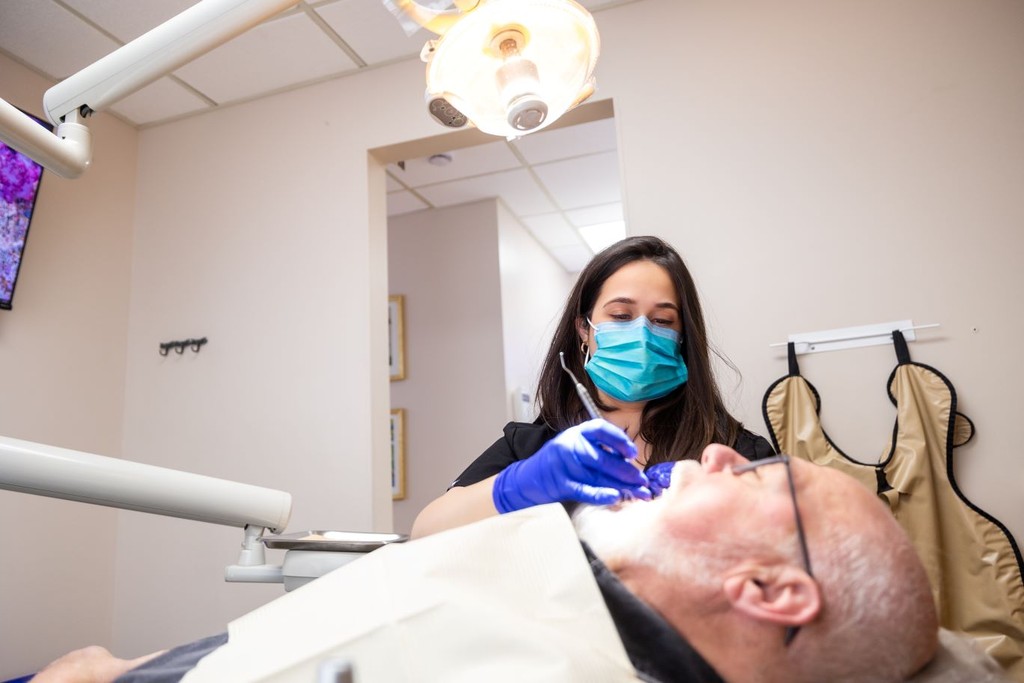 Dental hygienist performing teeth cleaning in Newark & Milltown NJ