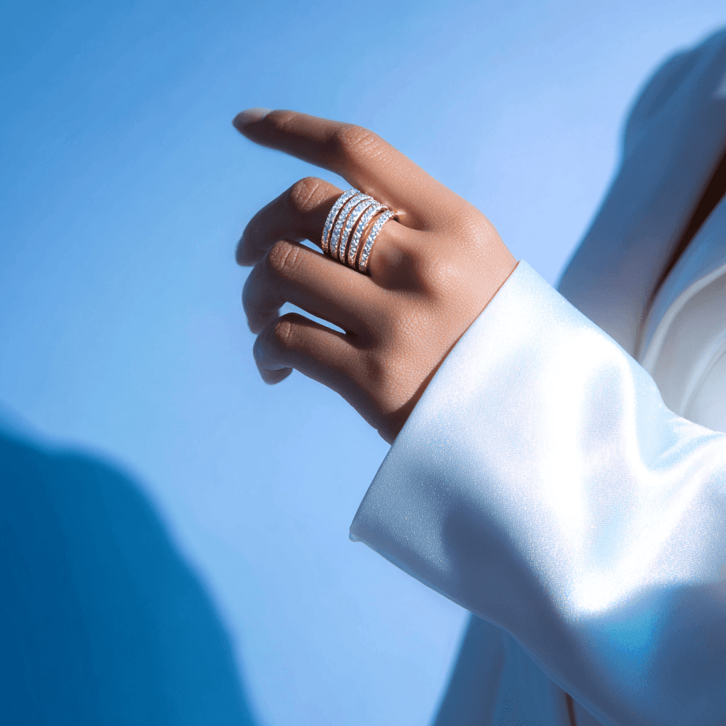 A close-up of a hand wearing multiple decorative rings against a blue background.