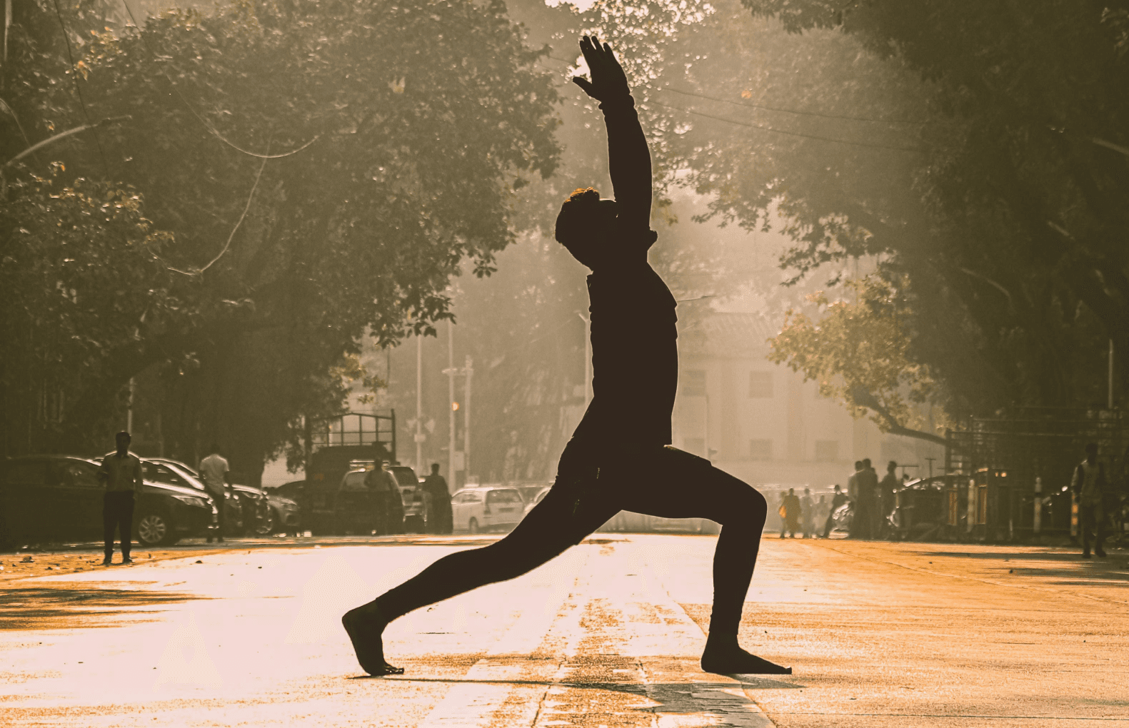 A cozy room with a wooden desk, computer, and warm sunlight streaming through a window.