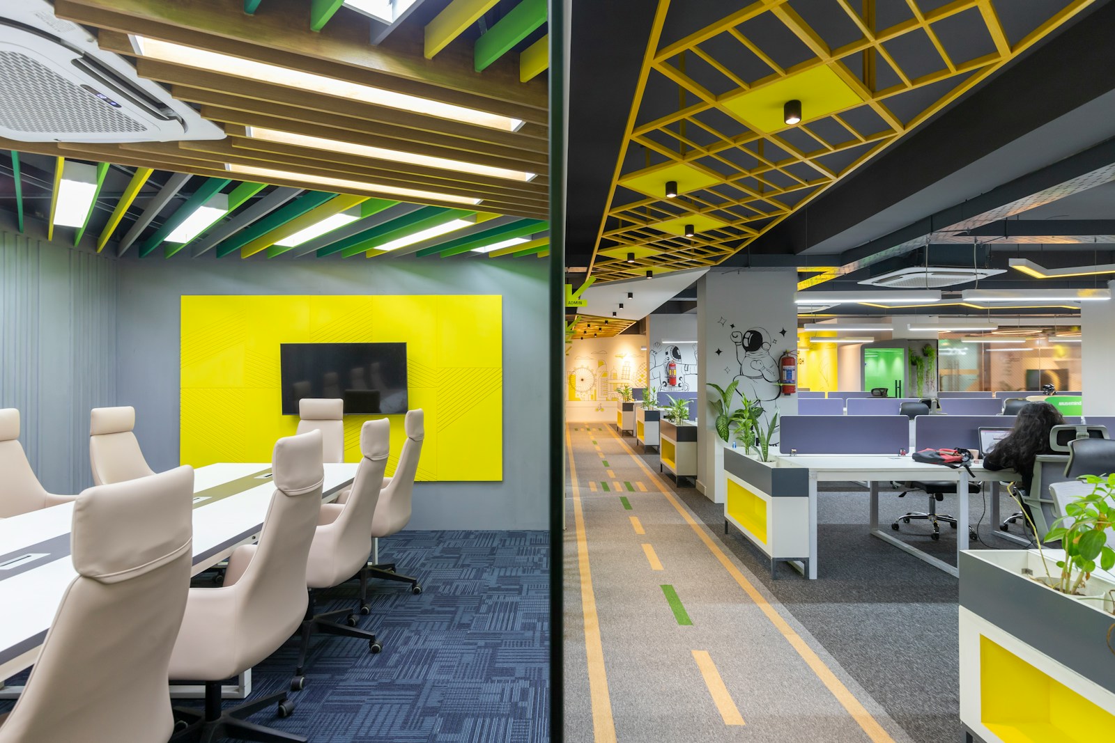 an office with yellow and grey walls and chairs