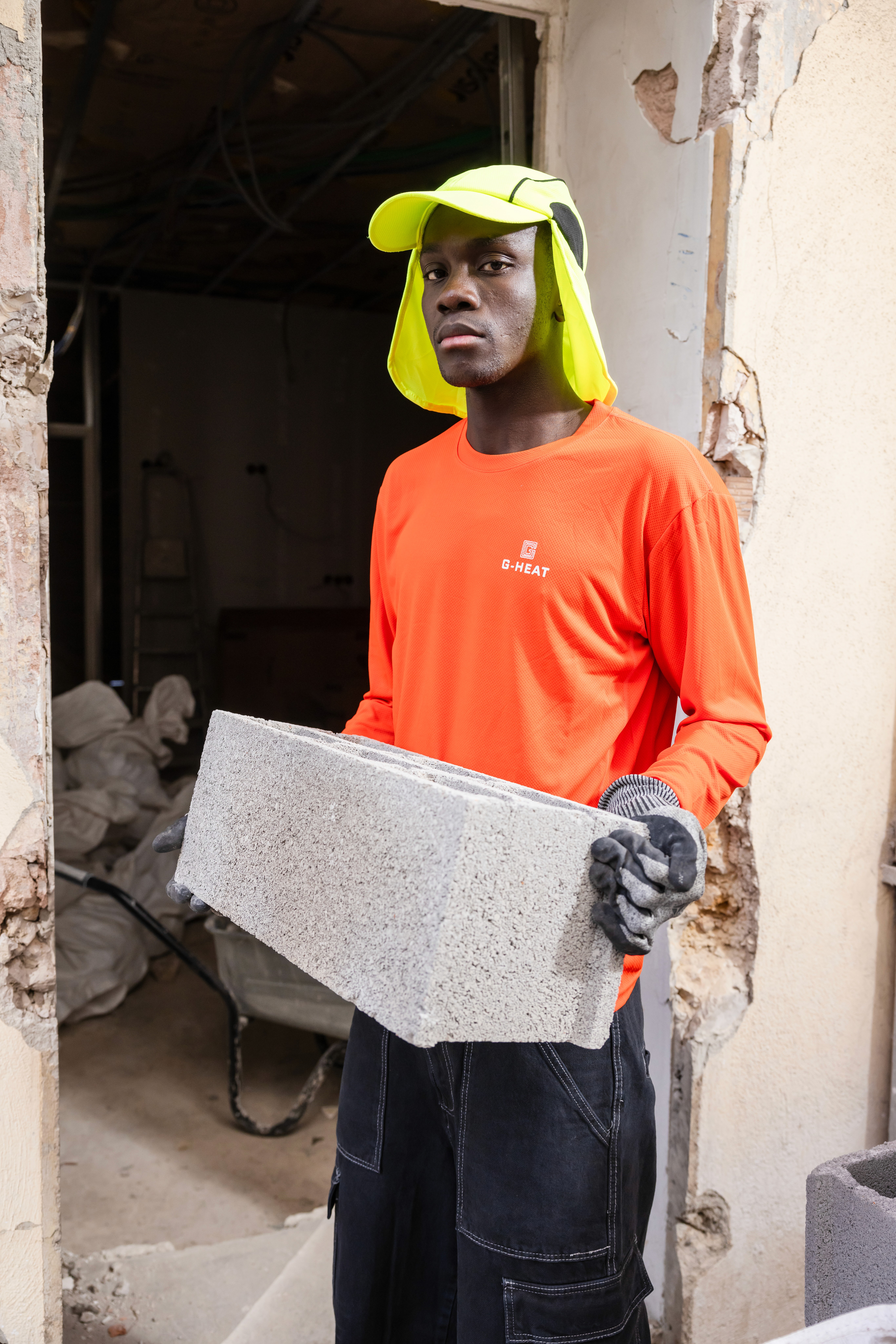 Construction worker wearing the orange G-Heat long-sleeve cooling shirt with a high-visibility Saharan cap on a construction site