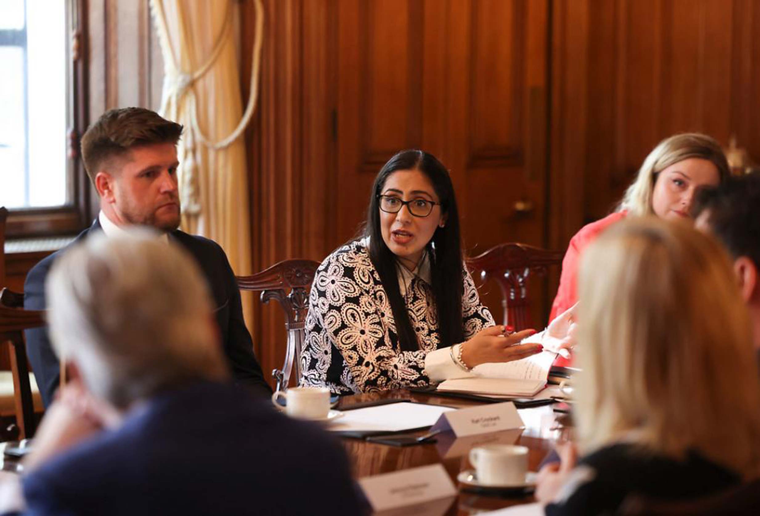 People seated around a table taking part in a formal meeting or discussion.