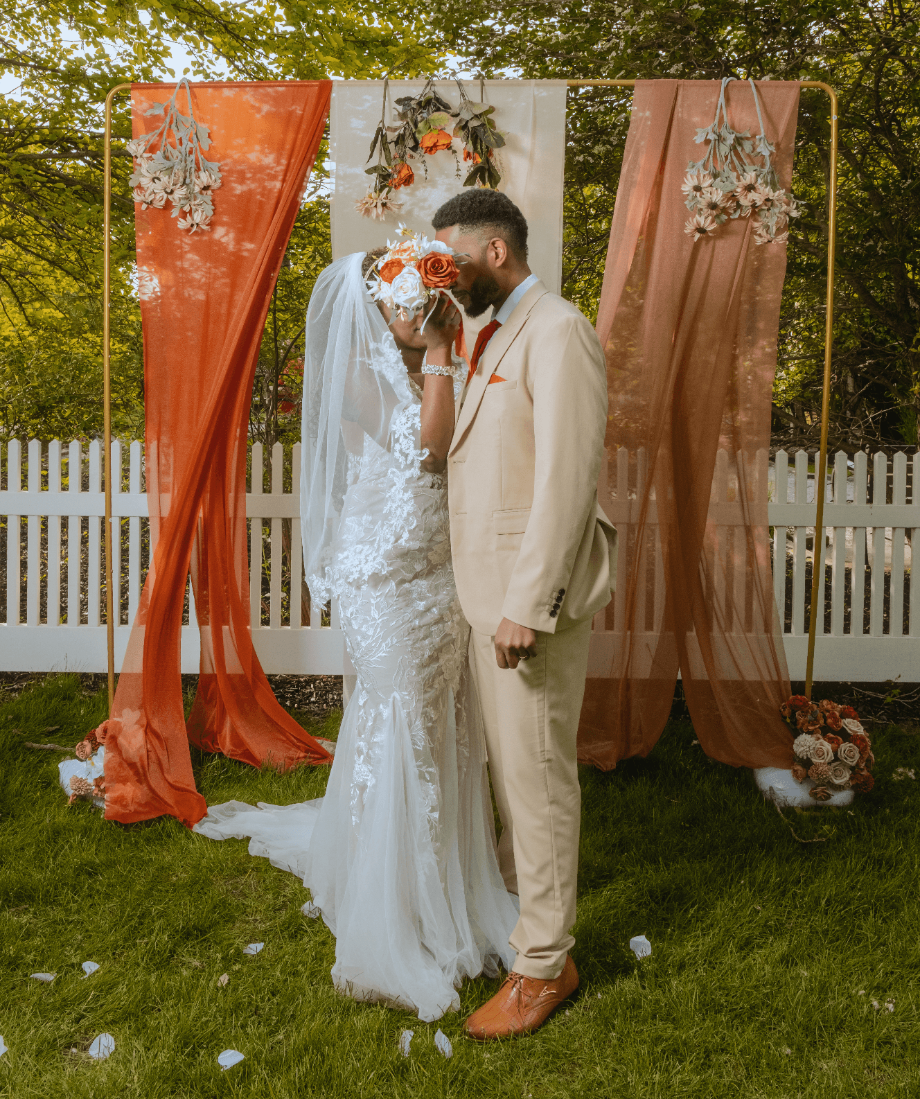 Married couple hiding behind bouqet of flowers