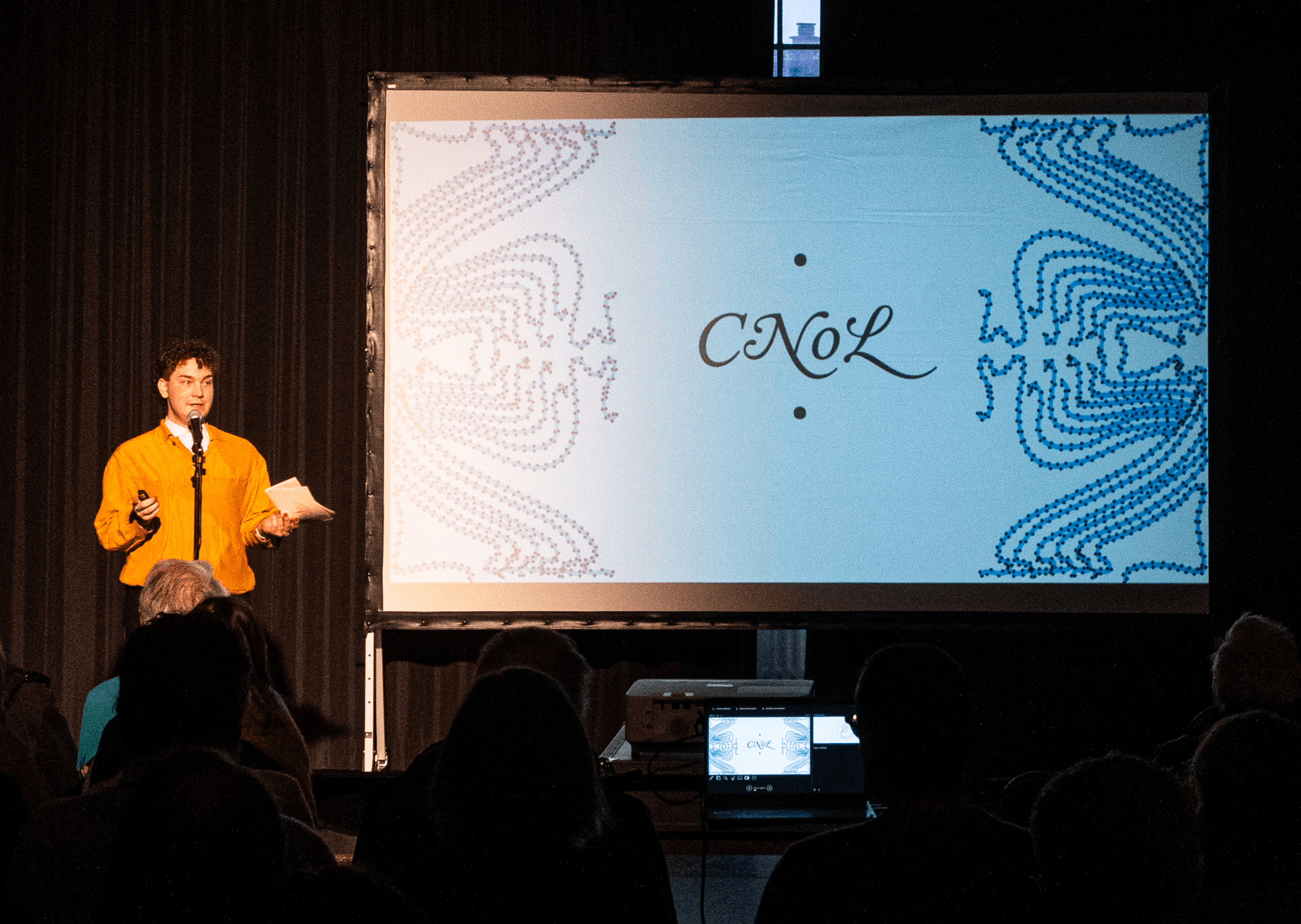 De foto toont de leidinggevende van CultuurNetwerk naast het presentatiebord.