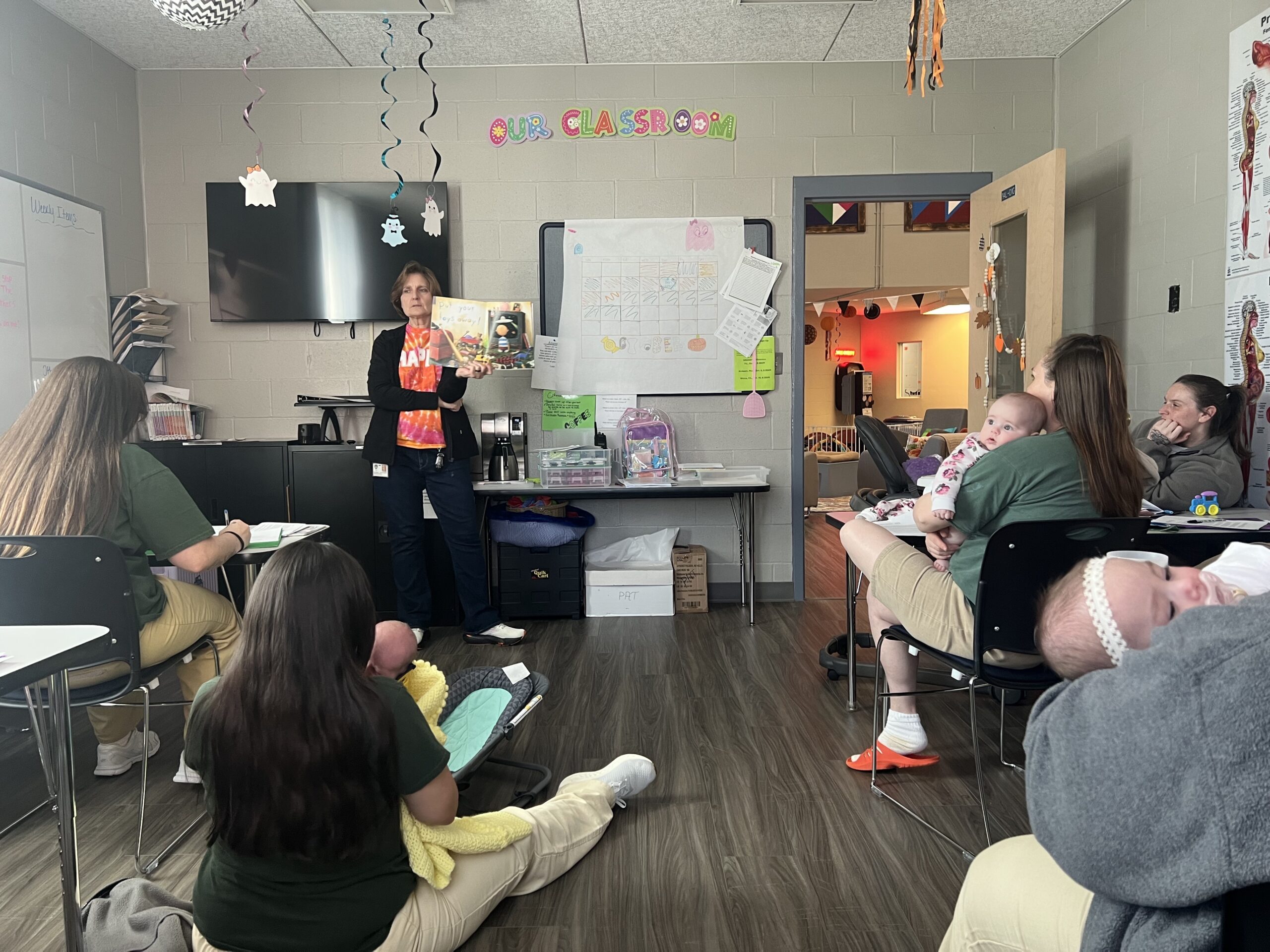 Parents as Teachers instructor Jill Whitaker reads a children’s book to moms and caregivers participating in a parenting class. Participants also complete worksheets and crafts designed to reinforce new ideas on motherhood and child development.