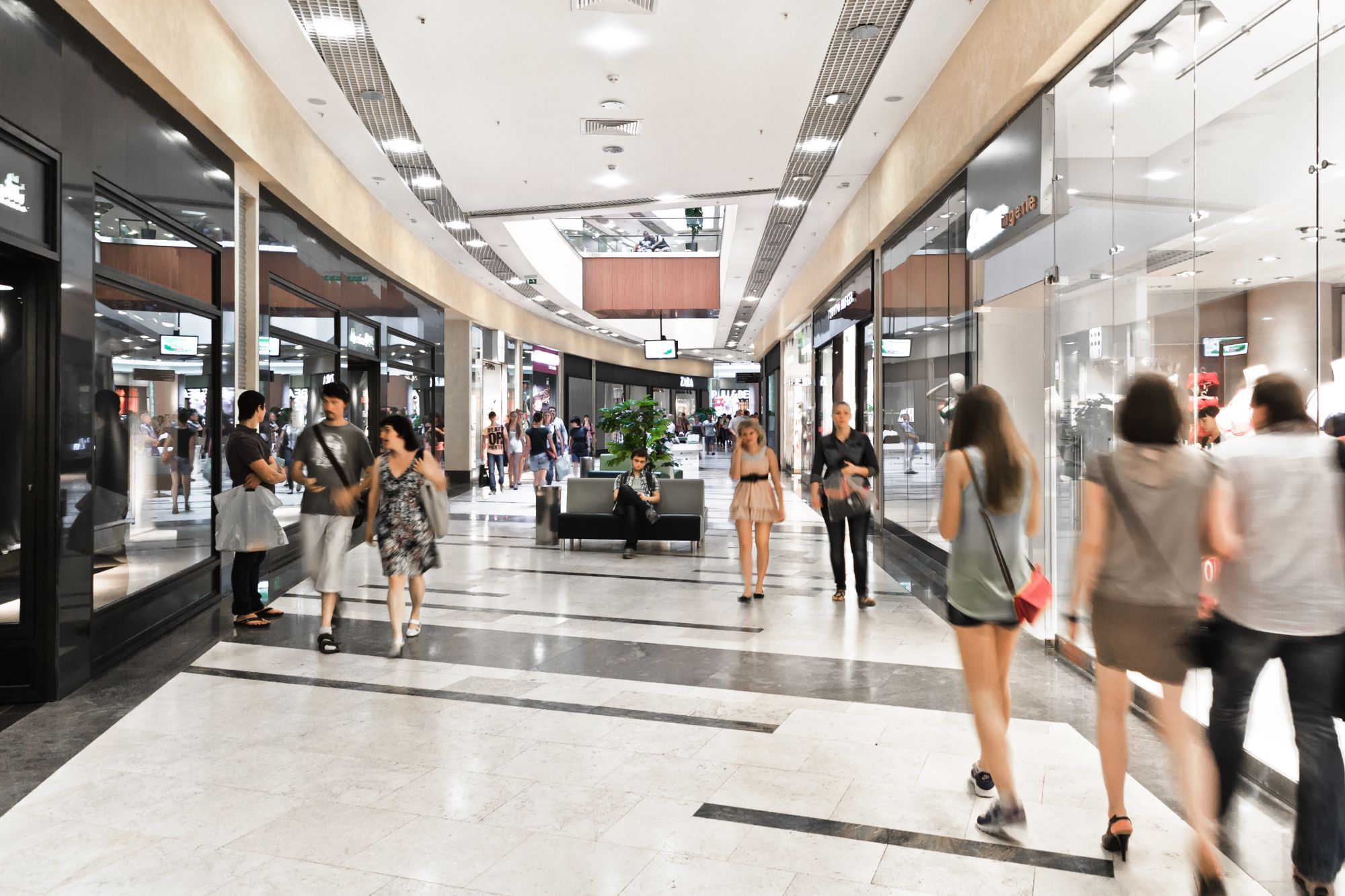 Shopping mall walkway lined with glass shopfronts