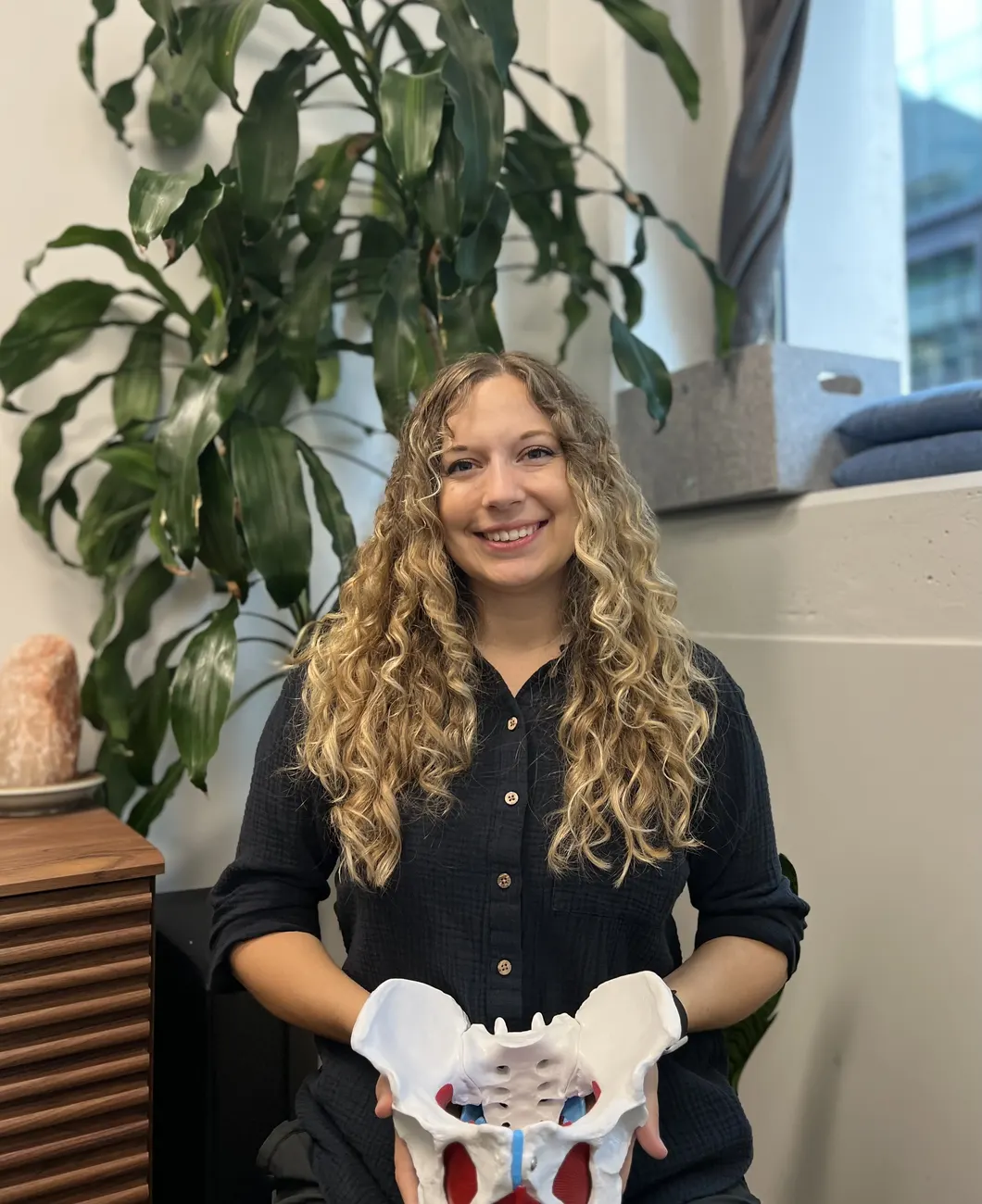 Teala McEwan with a pelvis model in the treatment room at Forza Physiotherapy