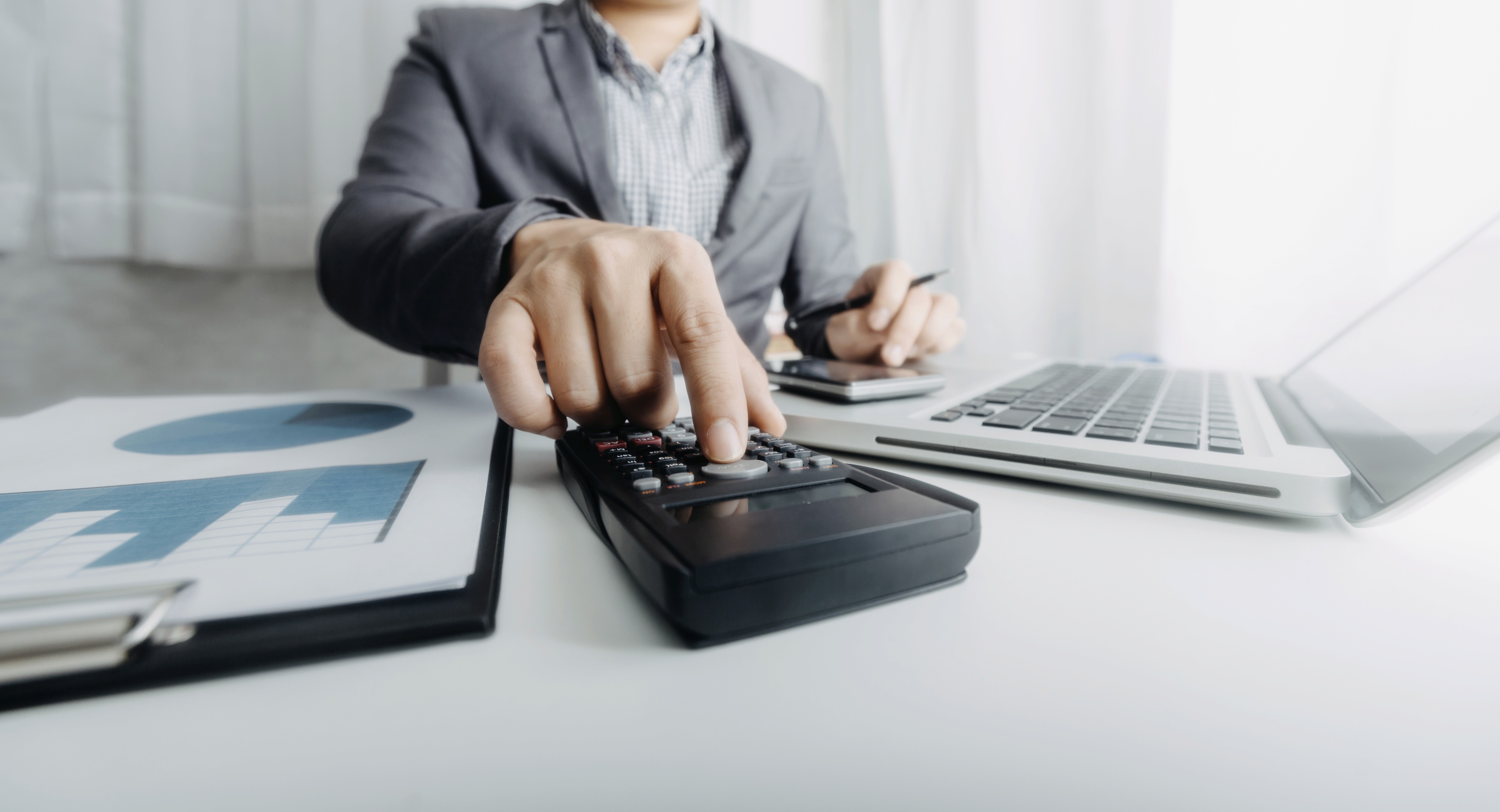 a group of people sitting around a table with laptops