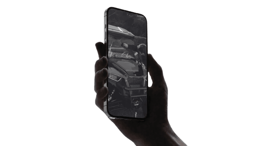 Hand holding a smartphone with a blank screen against a dark background.