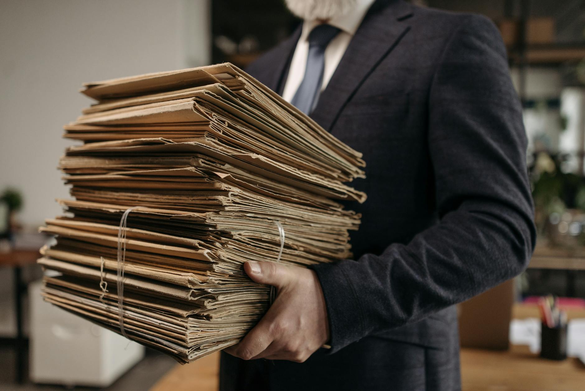 A teacher sitting at a desk organizing color-coded folders to maximize instructional minutes and class time.