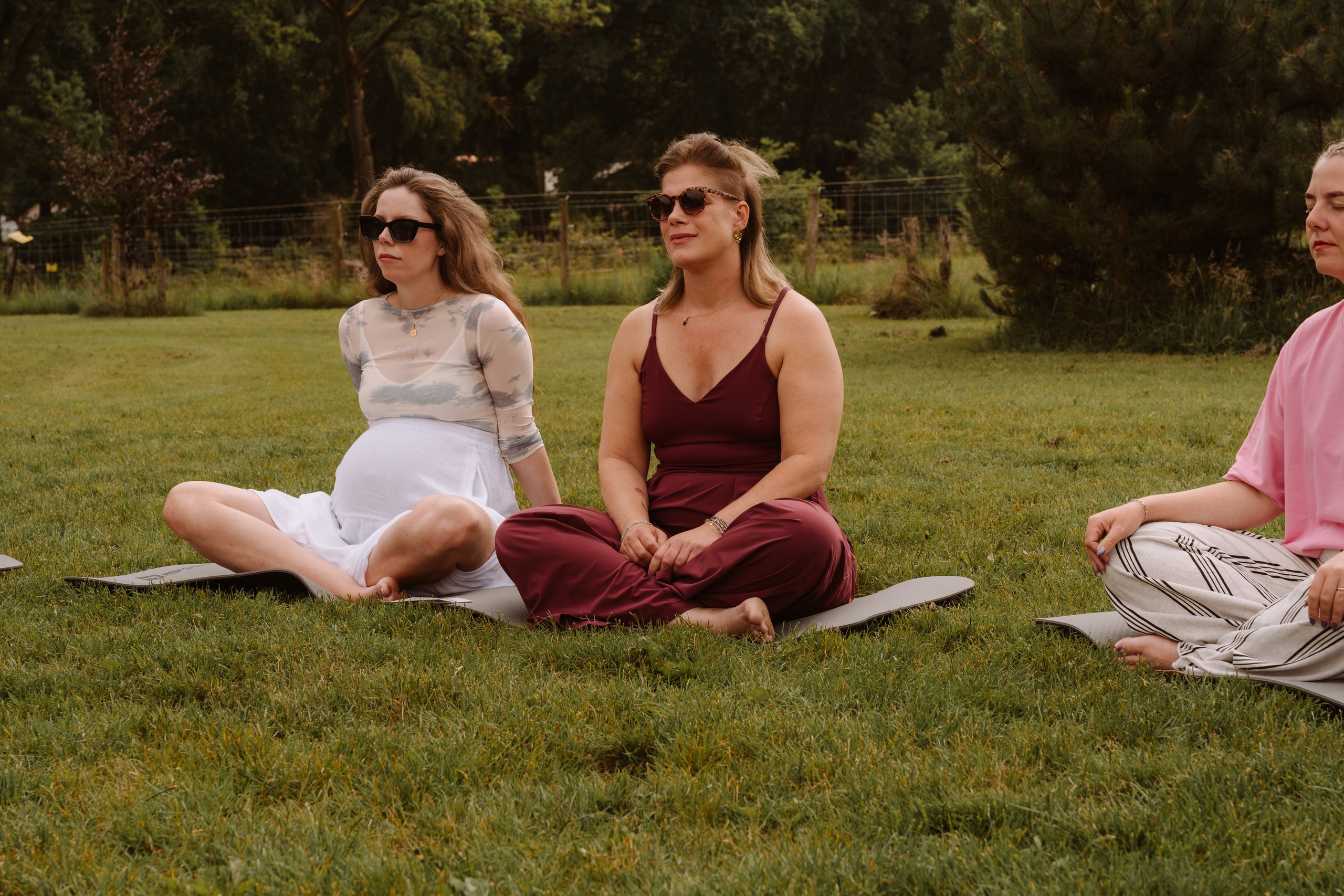 Twee vrouwen in gesprek op een mat in het gras