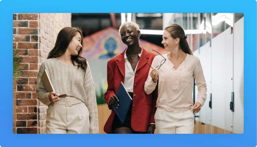 Three woman in a good mood walking trough the office holding briefcases