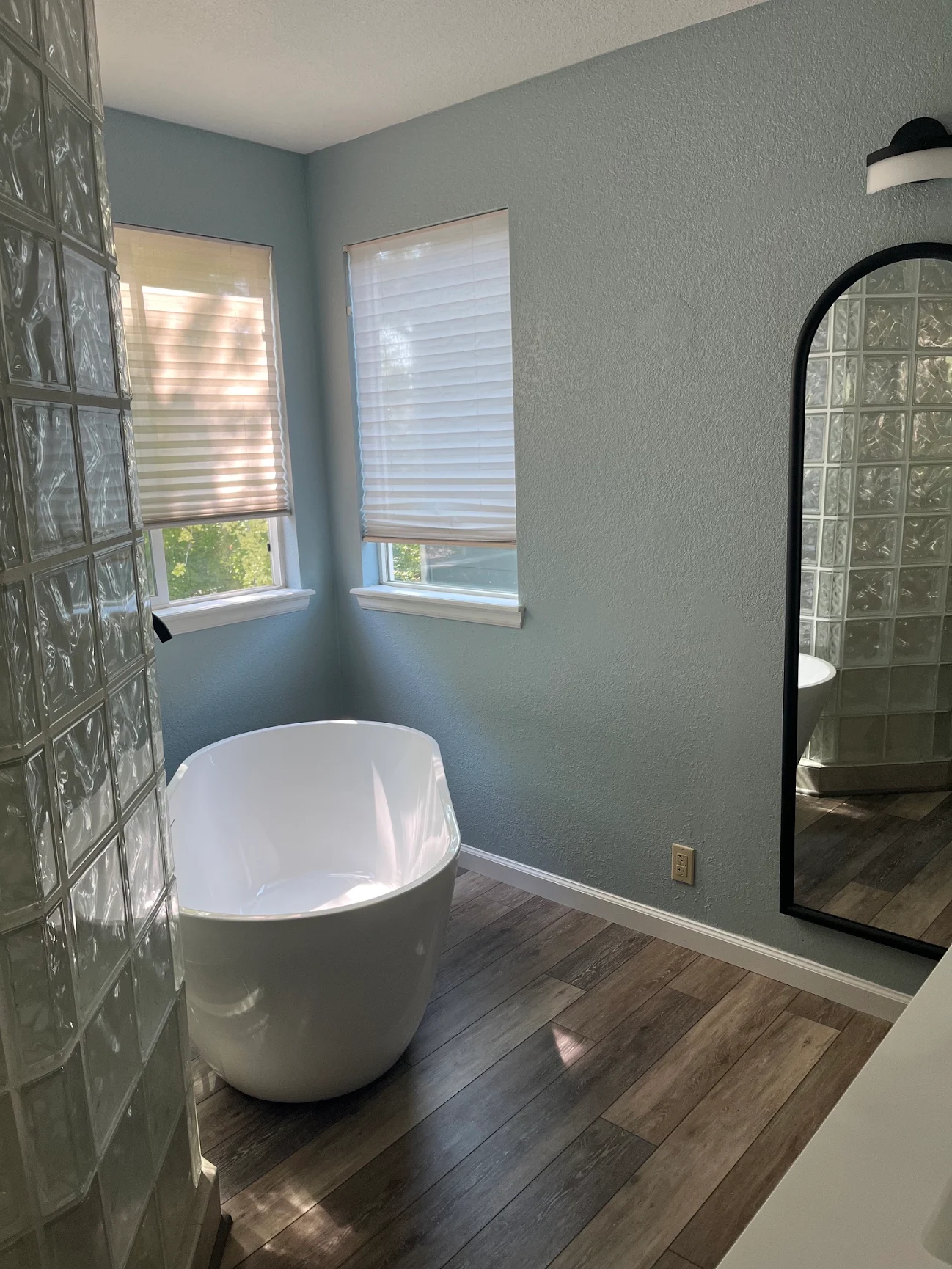 white ceramic bathtub near green potted plant