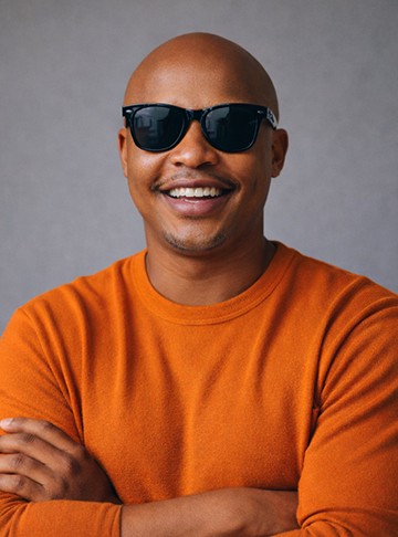 Smiling man wearing sun glasses with orange sweater