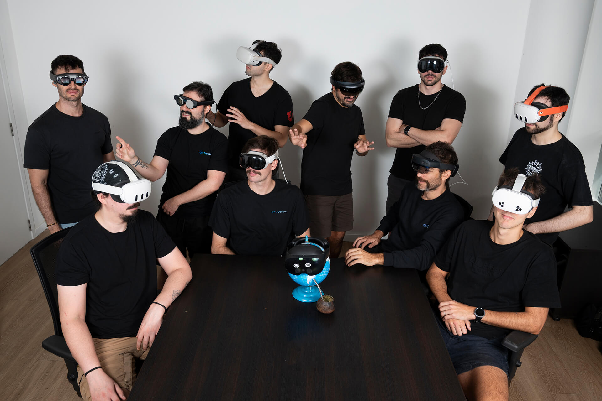 Four diverse professionals collaboratively working on a laptop, with one person pointing at the screen while others observe.