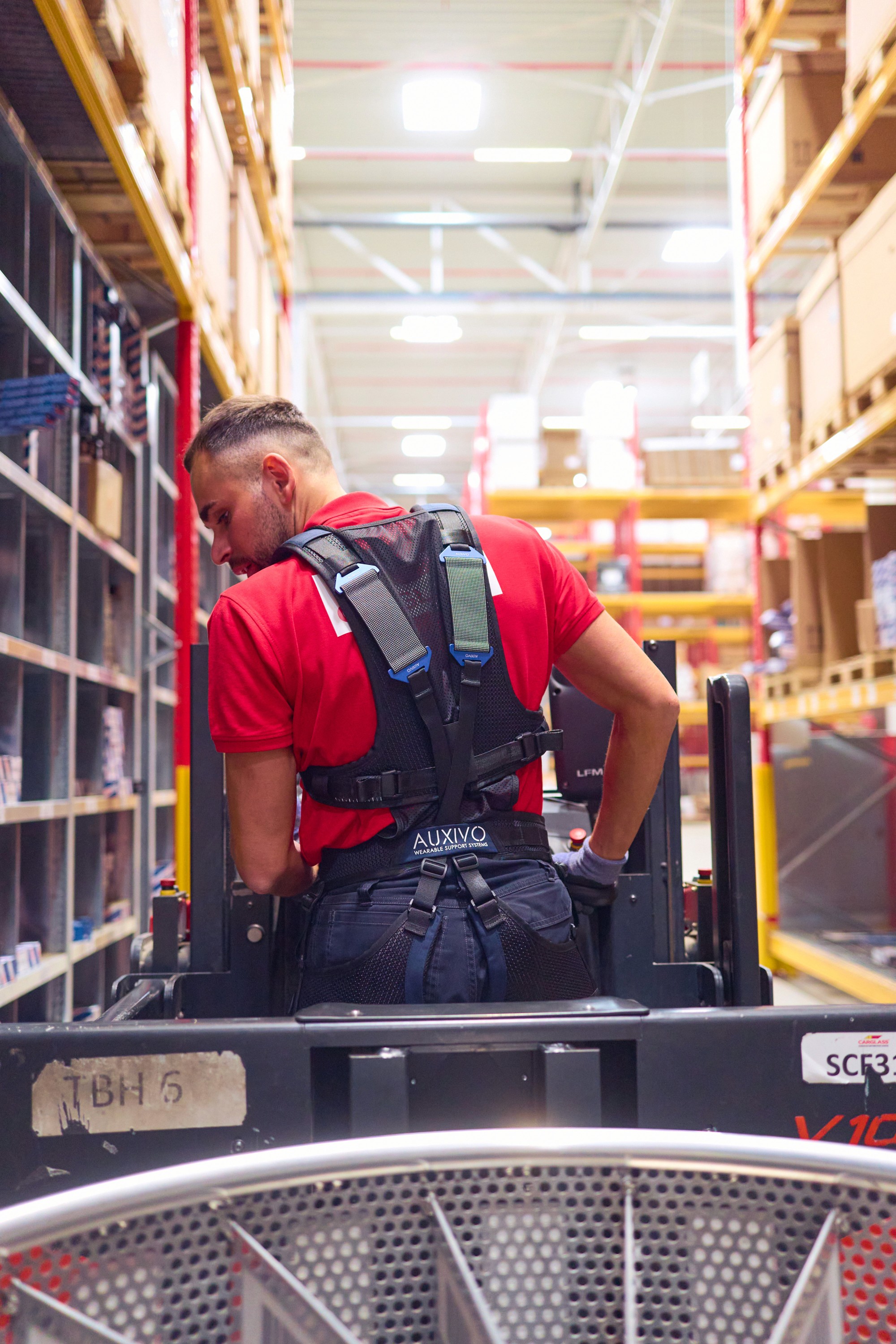 Warehouse worker in Moncton using LiftSuit exoskeleton to reduce back strain during material handling tasks