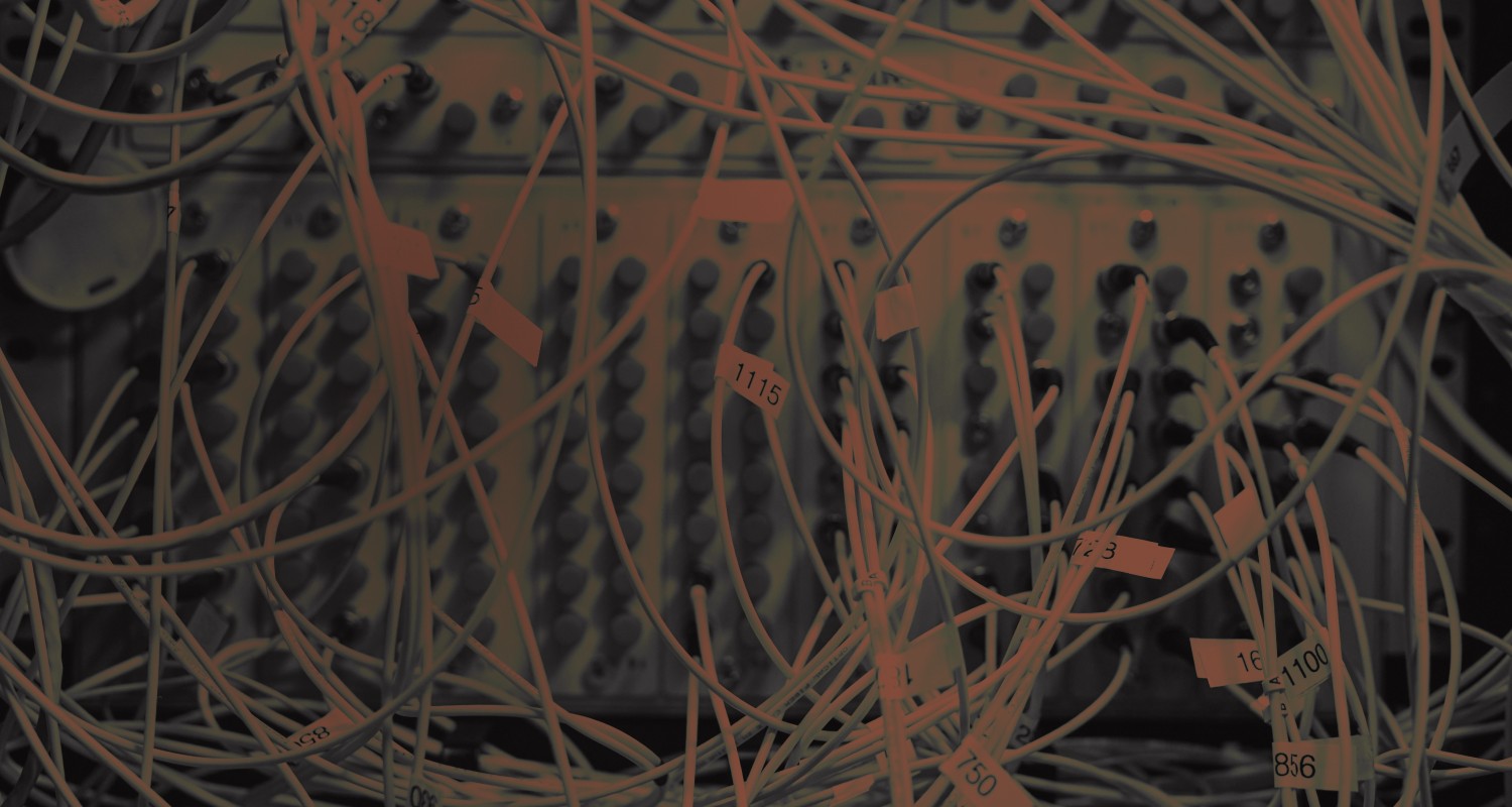 Photo of a messy server cabinet with lots of wires everywhere