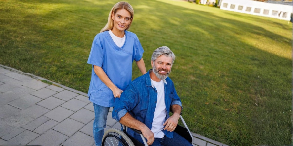 A caregiver assists a senior man in a wheelchair, reflecting the importance of personalized care and support for dementia.