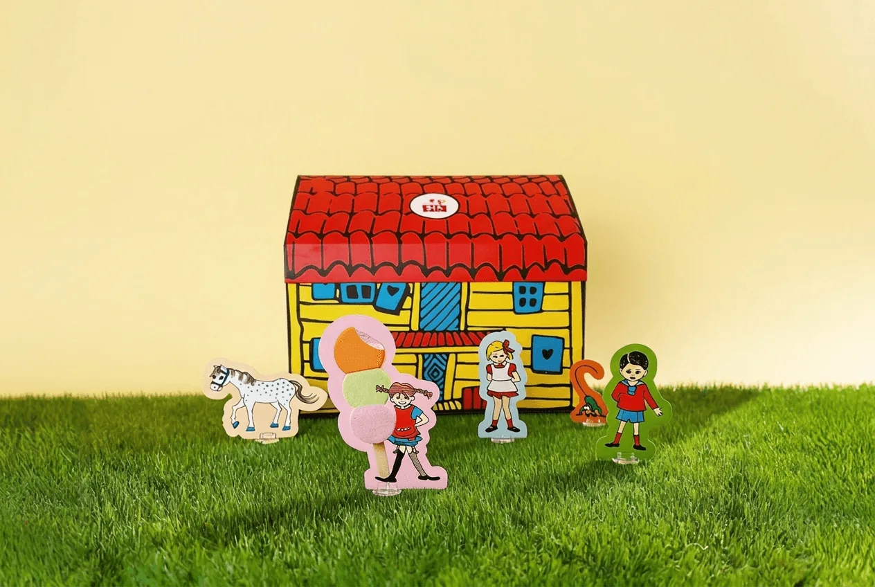 Kartongen som Villa Villekulla med utklippta figurer av Pippi och vännerna på gräset
