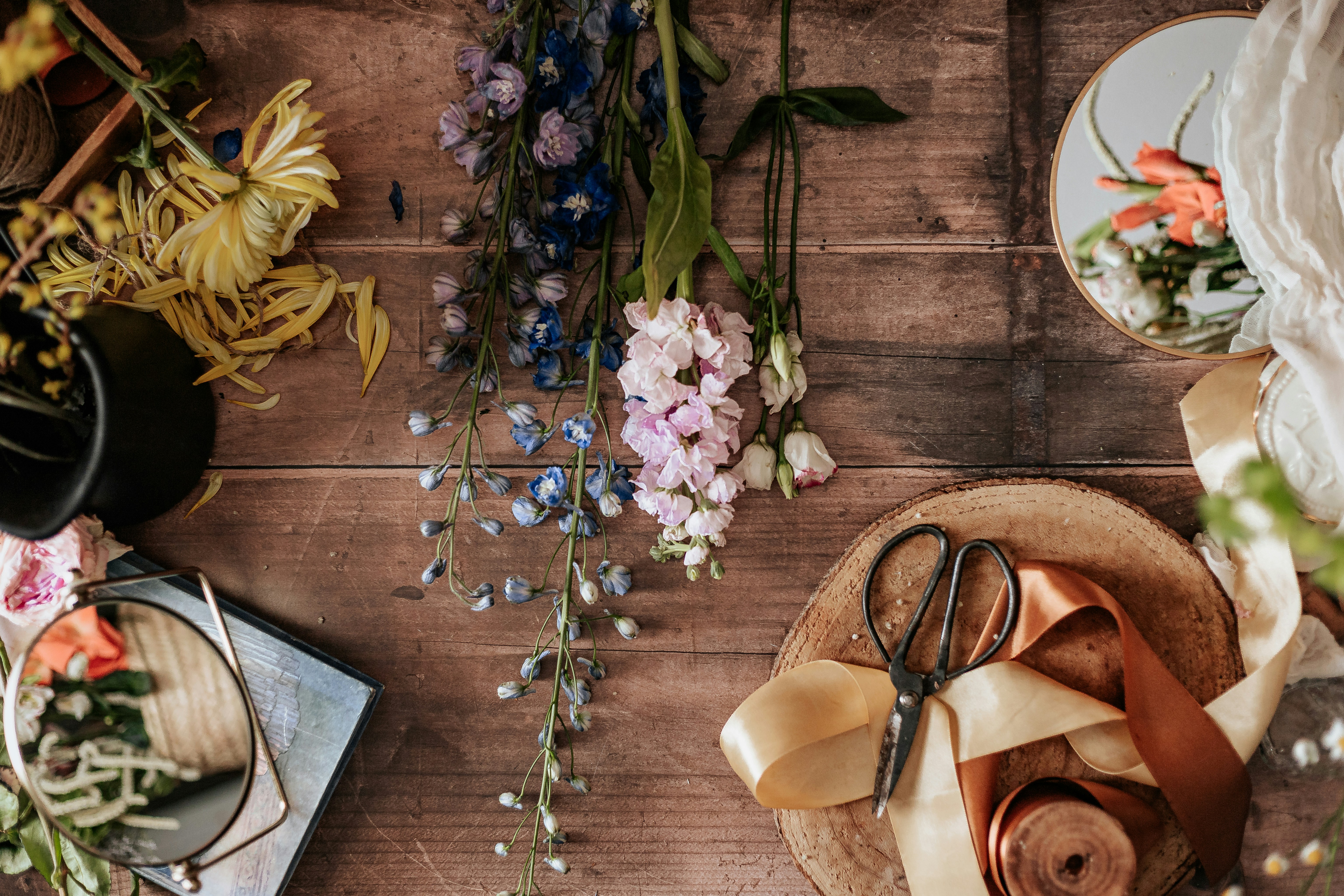 Flowers, ribbon and shears laid out on a florist’s table