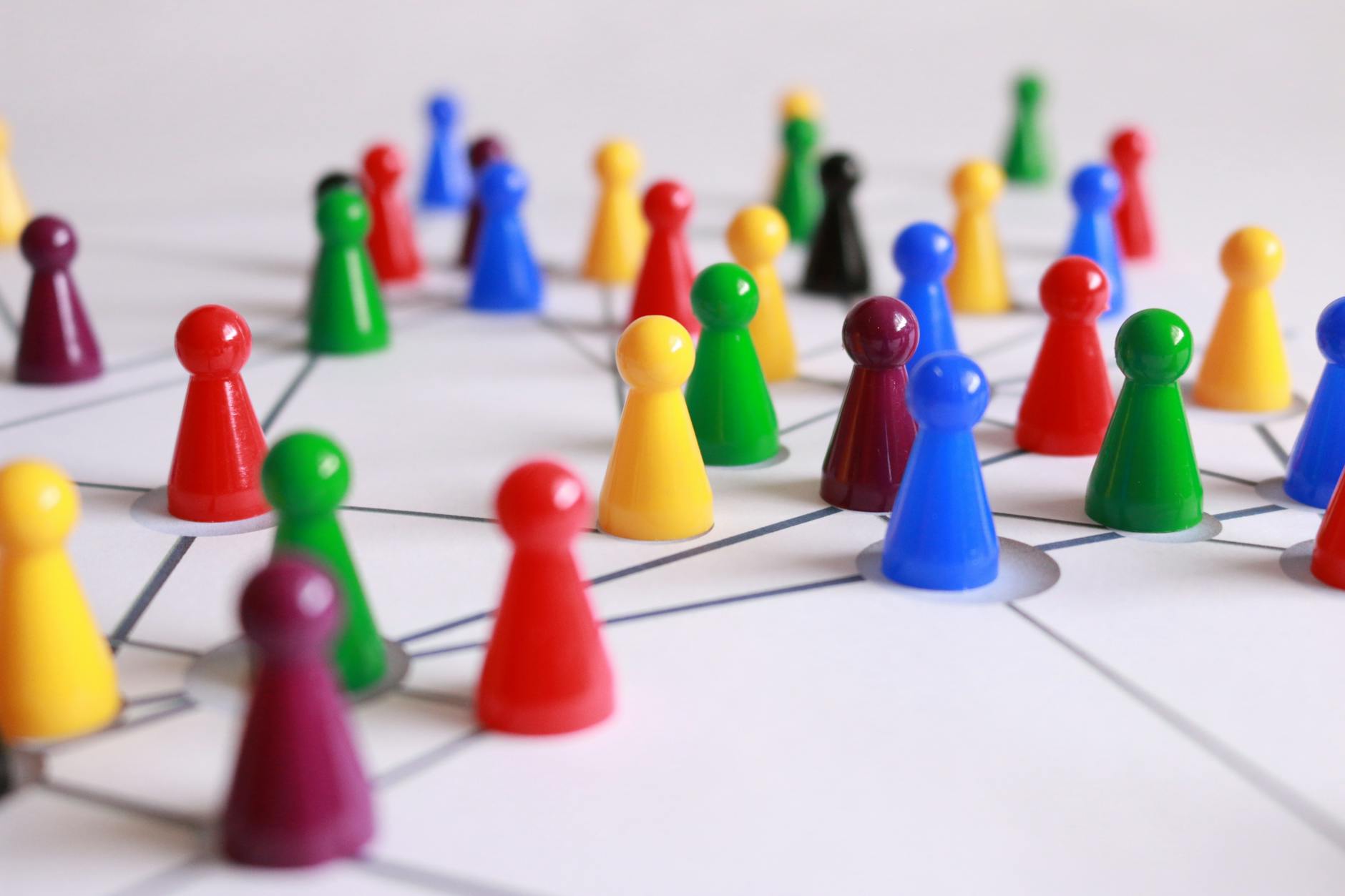 Close-up of a teacher's hands sorting through educational flashcards and board game pieces on a wooden table.