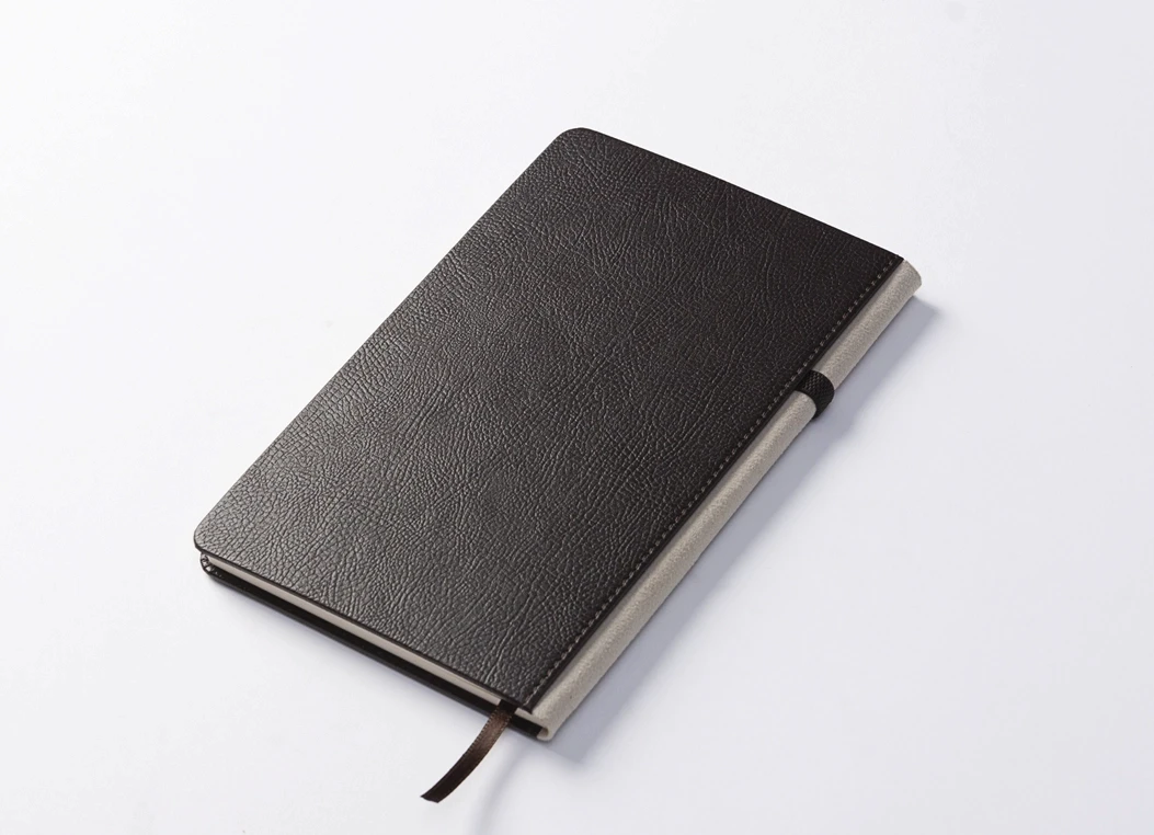 Closed textured leather journal with contrast spine detail