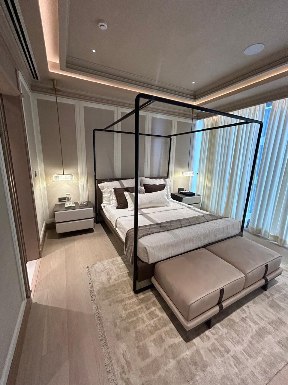 Elegant master bedroom with four-poster bed, soft drapes, and curated art pieces.