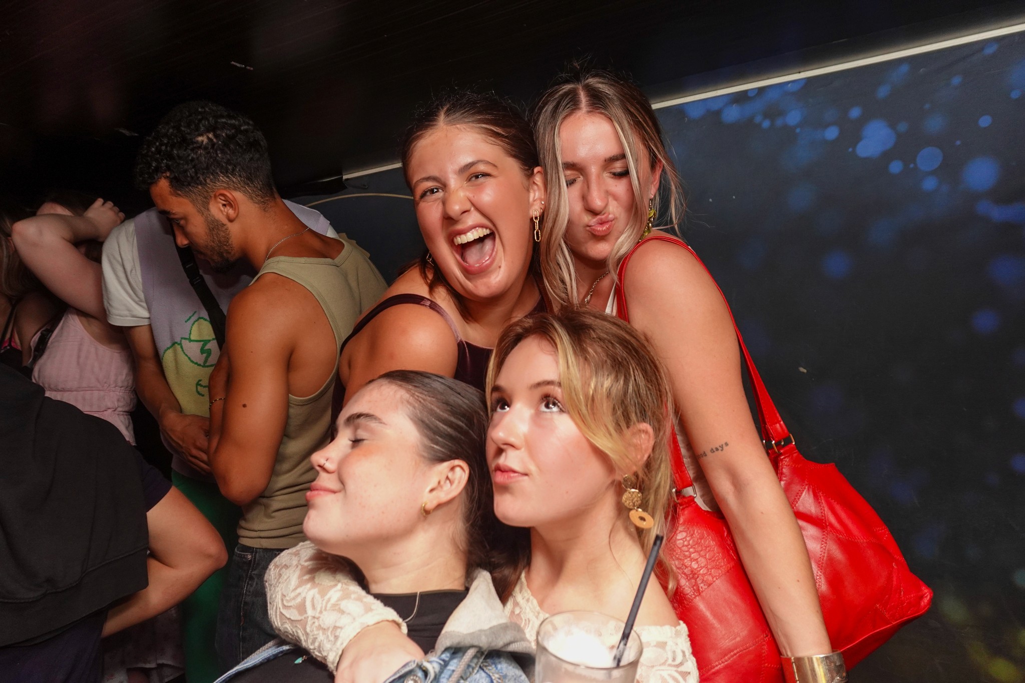 A group of young travelers enjoying nightlife in Nice, walking between affordable bars in the Old Town at night.
