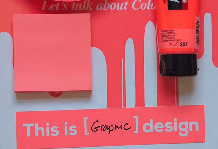 The image shows a coral pink sticky note placed on the left side of a red background. The red background has a design featuring white hand shapes and a vertical white line. A black cap is positioned on the right side of the red background. Centered on the red background is the text "This is [Graphic] design" in white letters. A portion of a tube of orange sunscreen is visible in the upper right corner of the image.