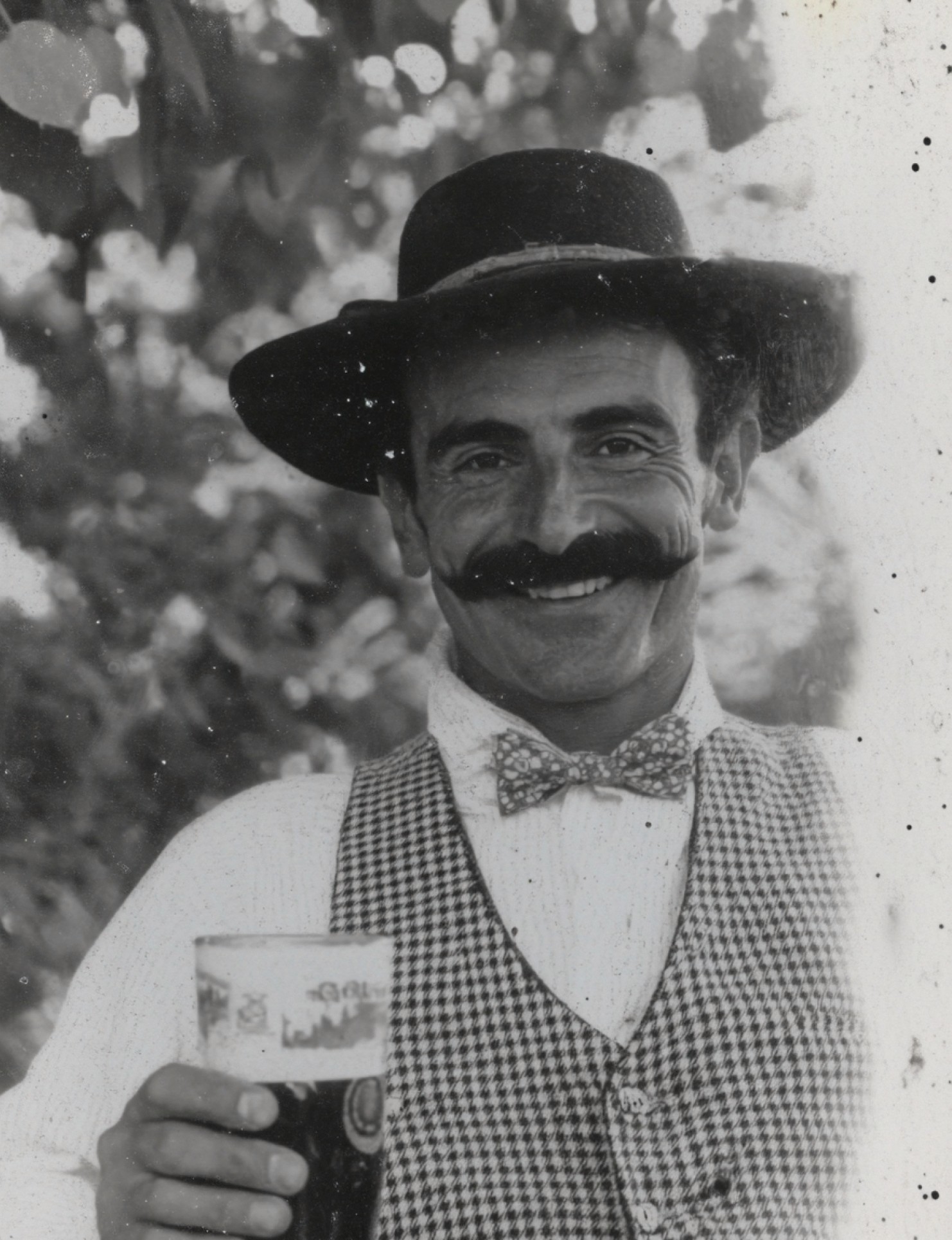 Black-and-white portrait photograph of man holding beer
