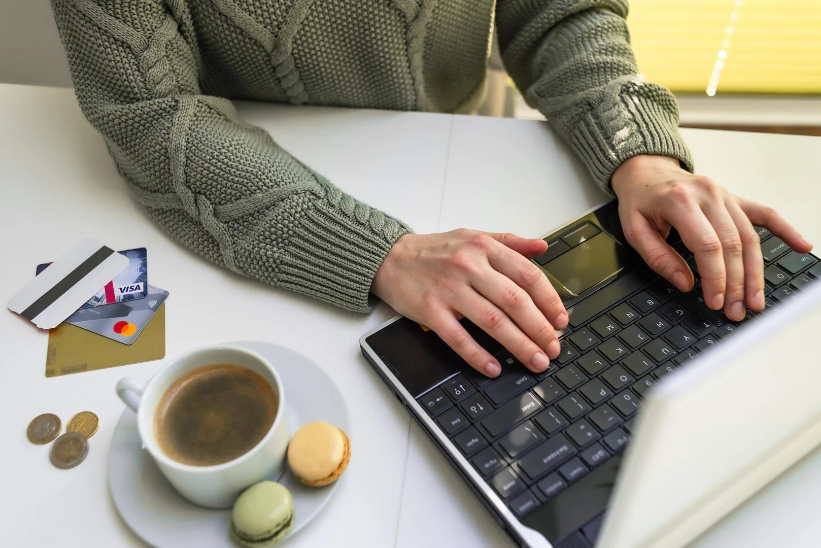 Hands use a laptop credit cards lie nearby businesswoman or entrepreneur working from home